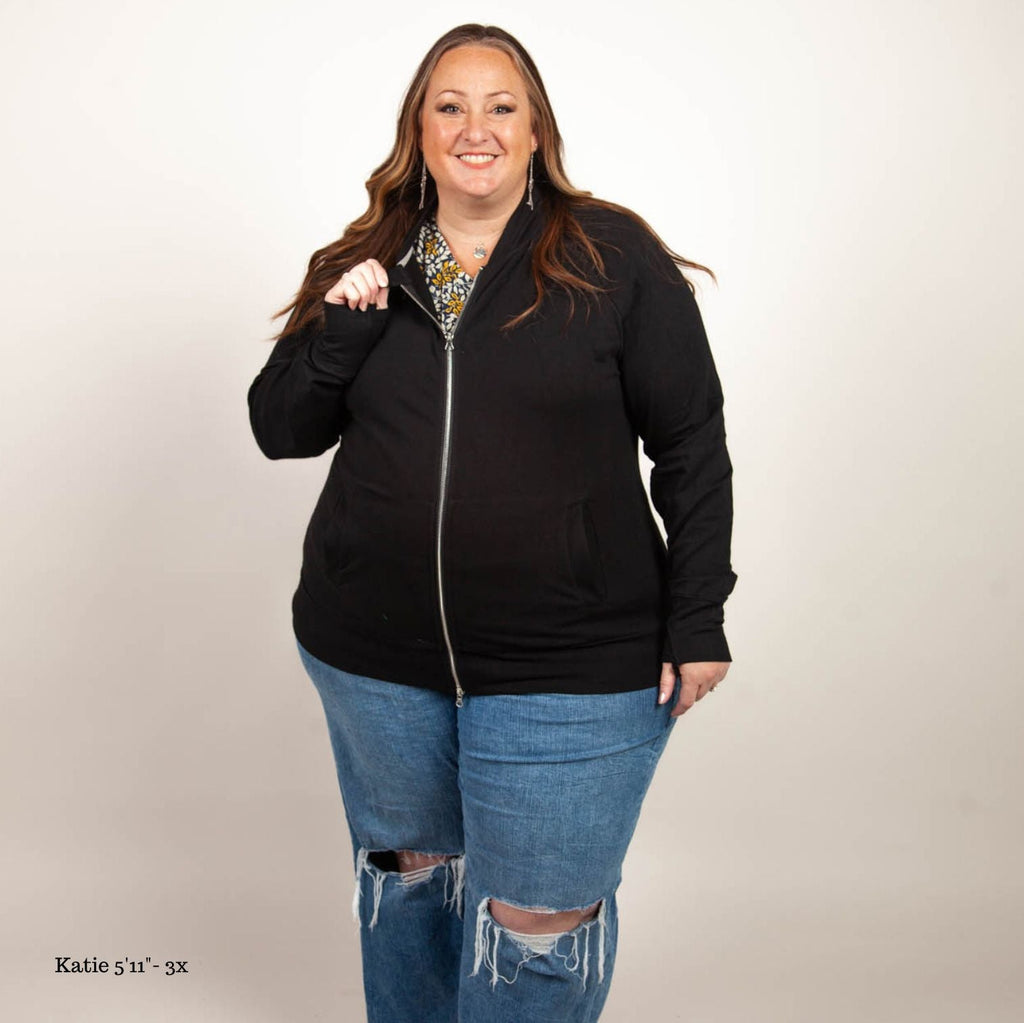 A woman wearing a black hoodless jacket with a stand collar, full front zipper, and thumbholes. shown in size 3XL
