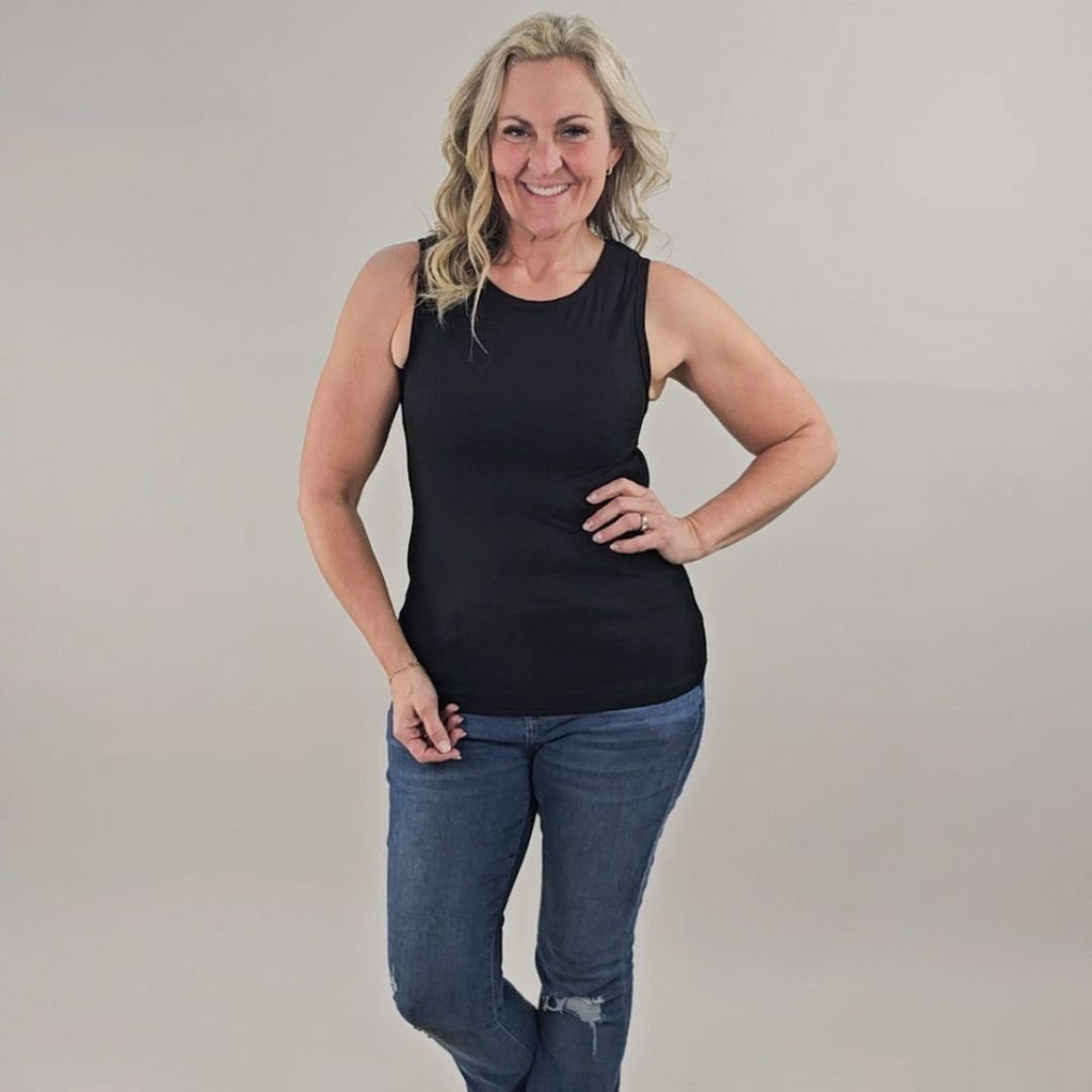 A woman wearing a black high-neck ribbed tank top. shown in size medium