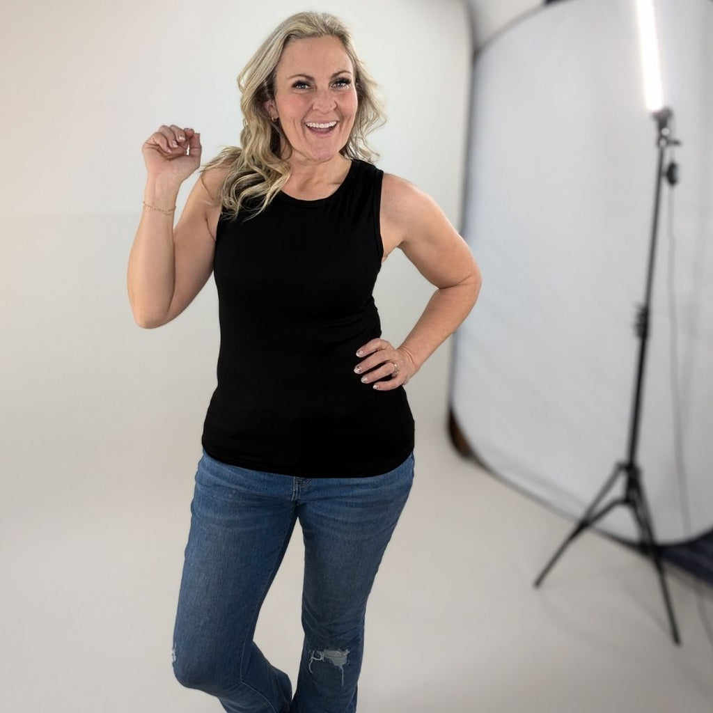 A woman wearing a black high-neck ribbed tank top. shown in size medium