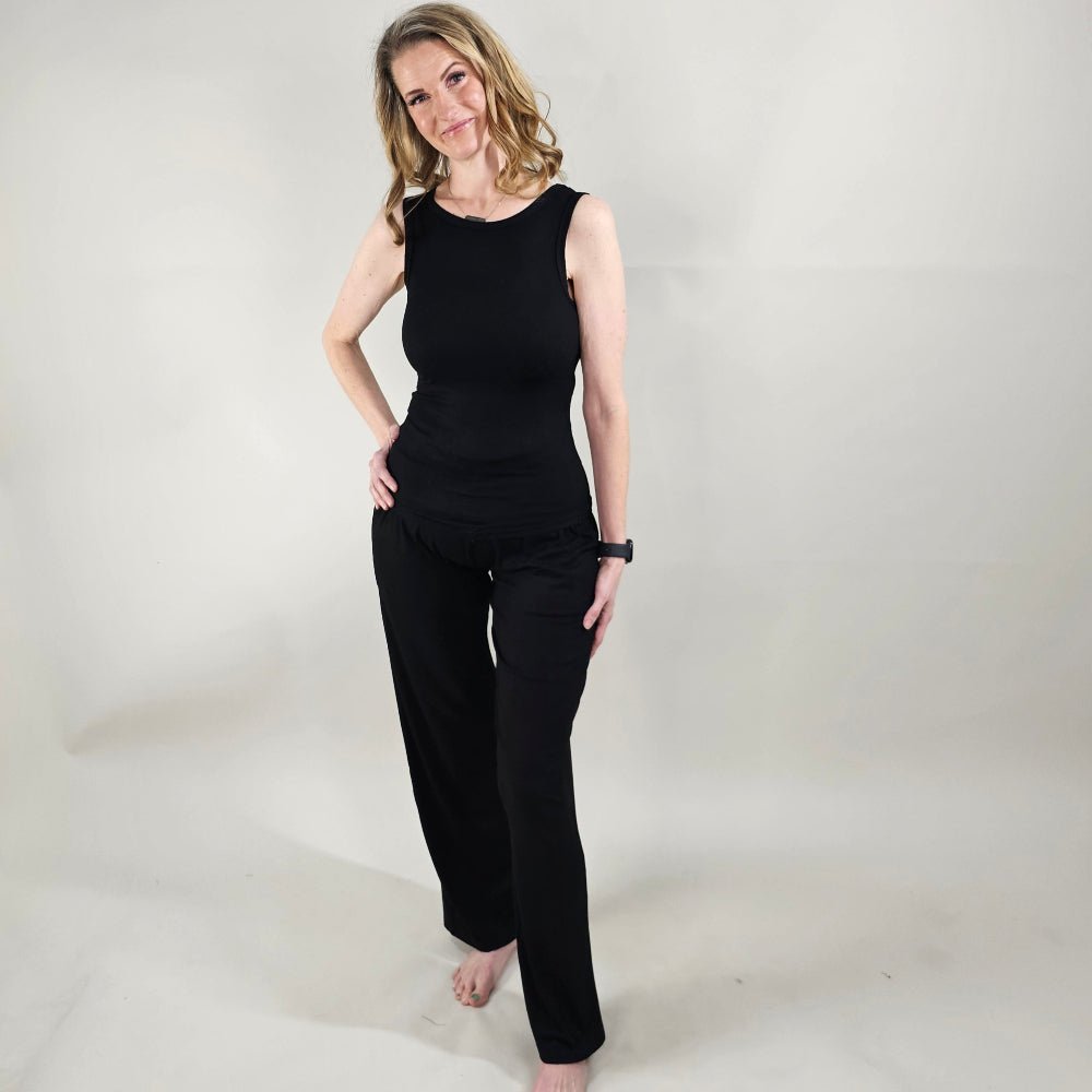 A woman wearing black ribbed wide-leg pants with a relaxed fit. paired with ribbed black tank top. shown in size XS. 