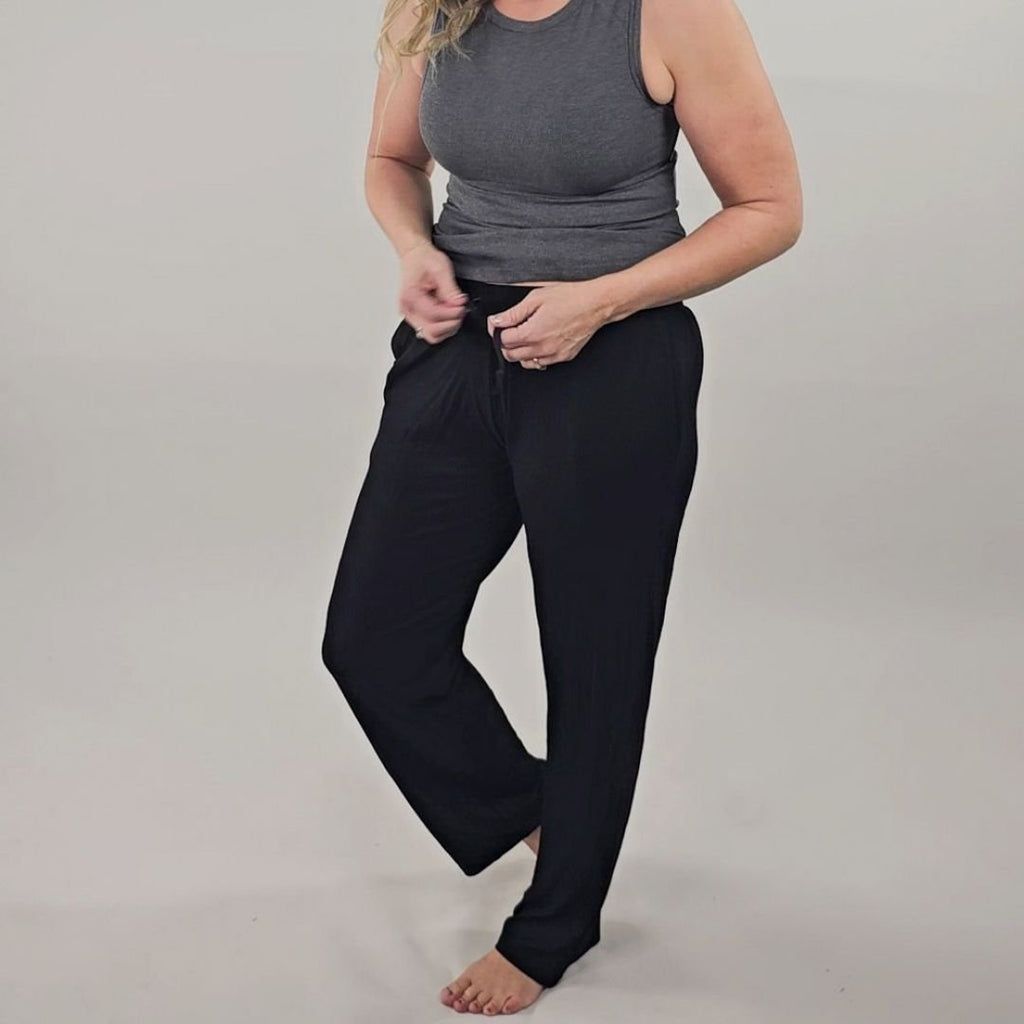 A woman wearing black ribbed wide-leg pants with a relaxed fit and draw string. shown in size medium. 