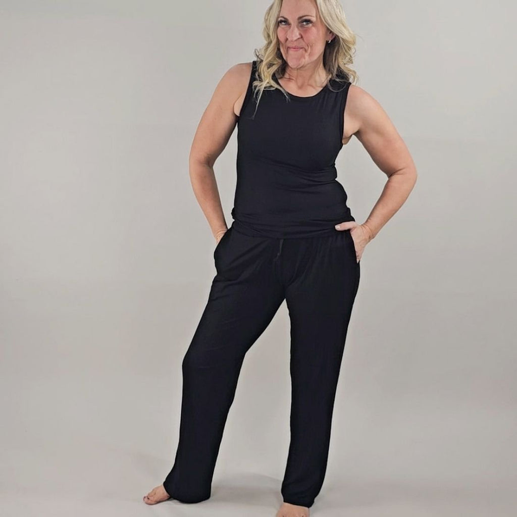 A woman wearing black ribbed wide-leg pants with a relaxed fit and paired with a black ribbed tank top. shown in size medium. 