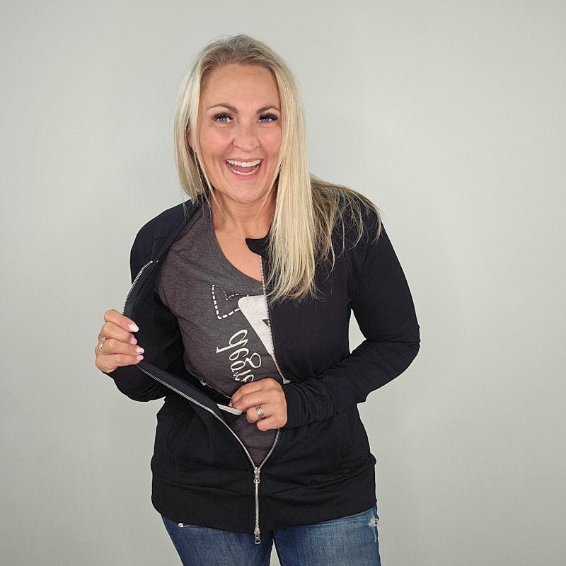 A woman wearing a black hoodless jacket with a stand collar, full front zipper, and thumbholes. shown in size medium