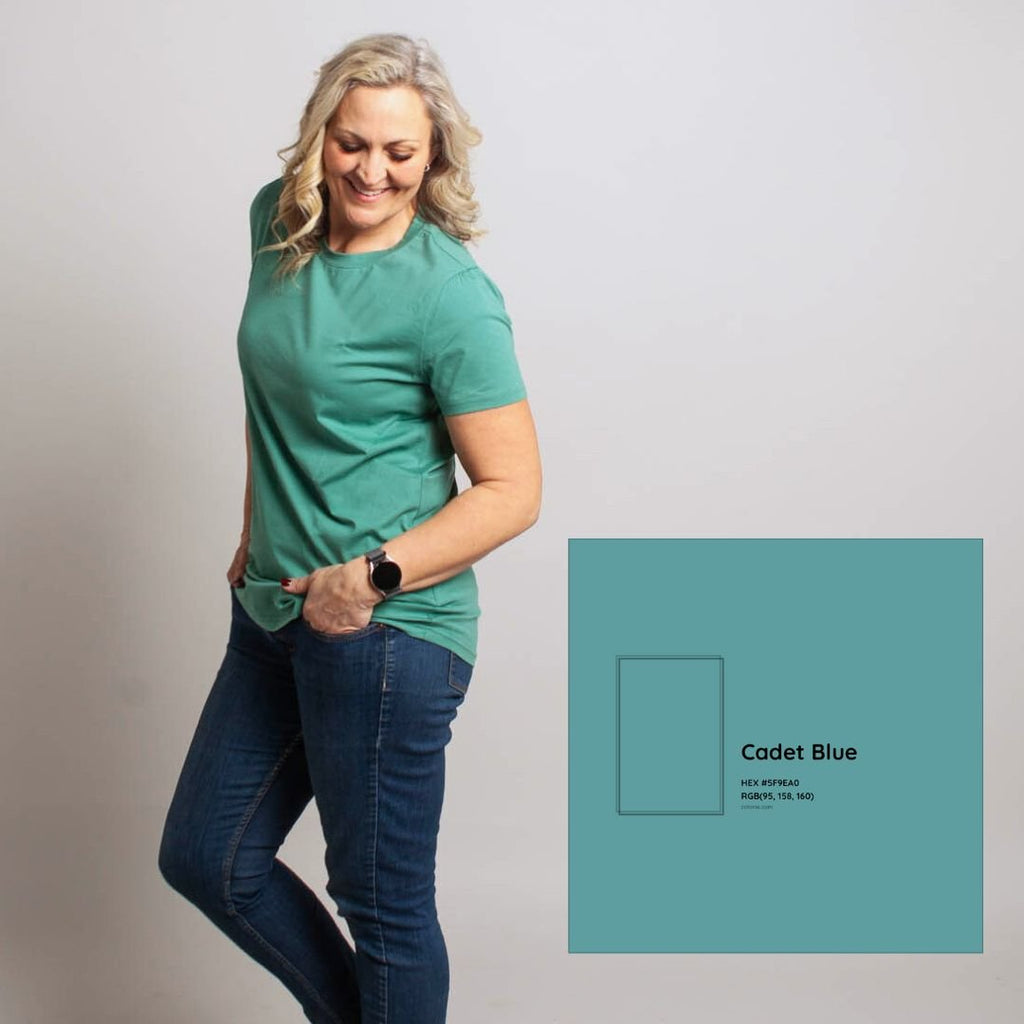 A woman wearing a relaxed fit crewneck shirt in cadet blue color. shown in size medium