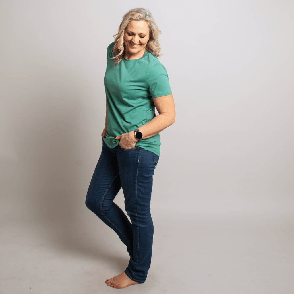 A woman wearing a relaxed fit crewneck shirt in cadet blue color. shown in size medium