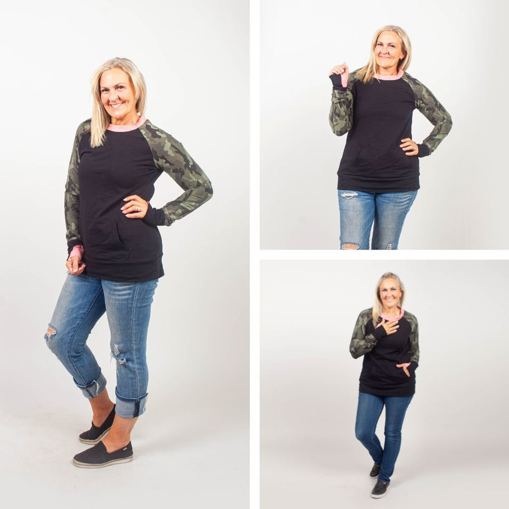 Camo Crush Crew Neck - women's relaxed fit long sleeve sweatshirt with front kangaroo pocket. long torso with longer back, soft lightweight stretchy fabric for comfort. color block black body with camouflage accent sleeves and coral accent neckline. black accent sleeve cuff with coral accent thumbhole. shown in size medium women
