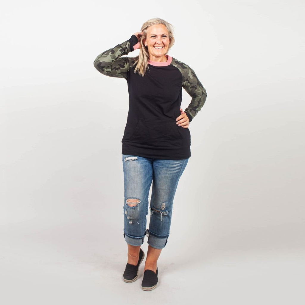 Camo Crush Crew Neck - women's relaxed fit long sleeve sweatshirt with front kangaroo pocket. long torso with longer back, soft lightweight stretchy fabric for comfort. color block black body with camouflage accent sleeves and coral accent neckline. black accent sleeve cuff with coral accent thumbhole. shown in size medium women