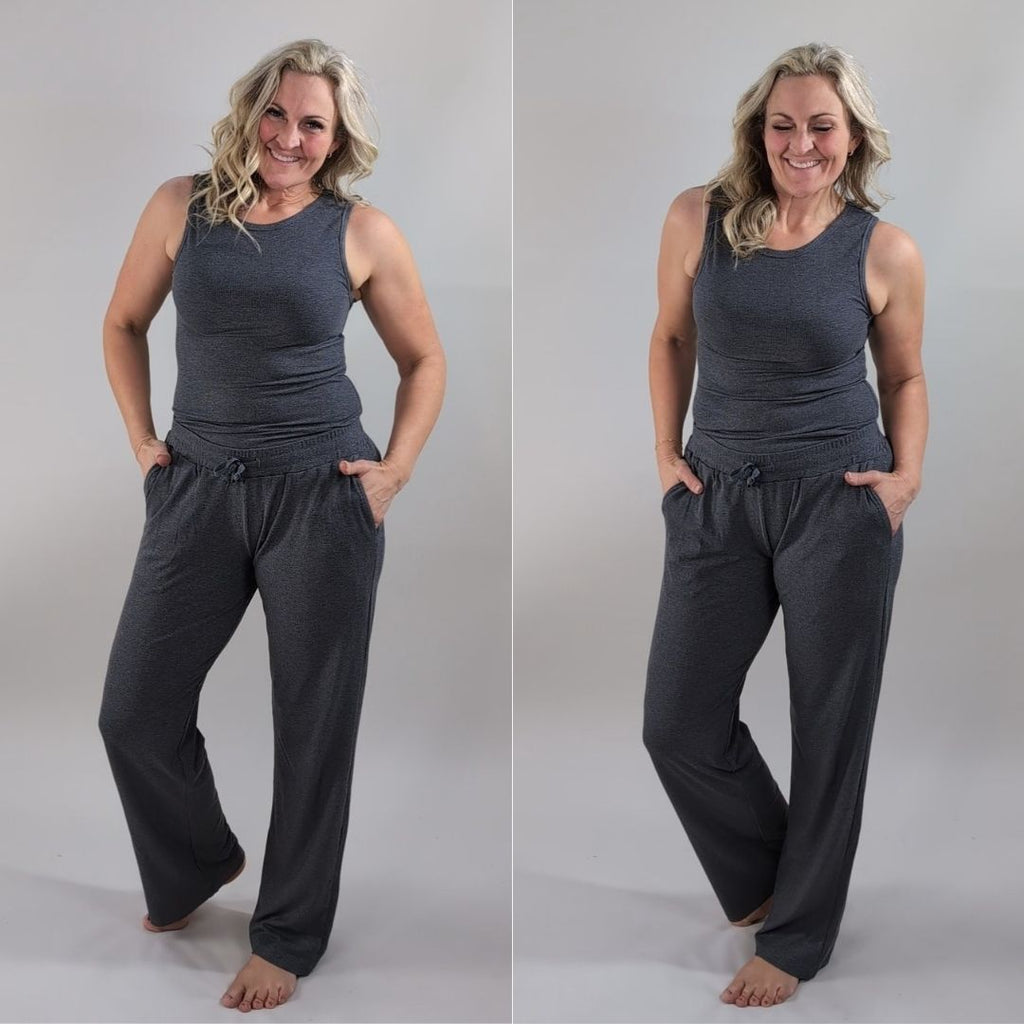 A woman wearing a dark grey ribbed high neck tank top and matching pants. shown in size medium