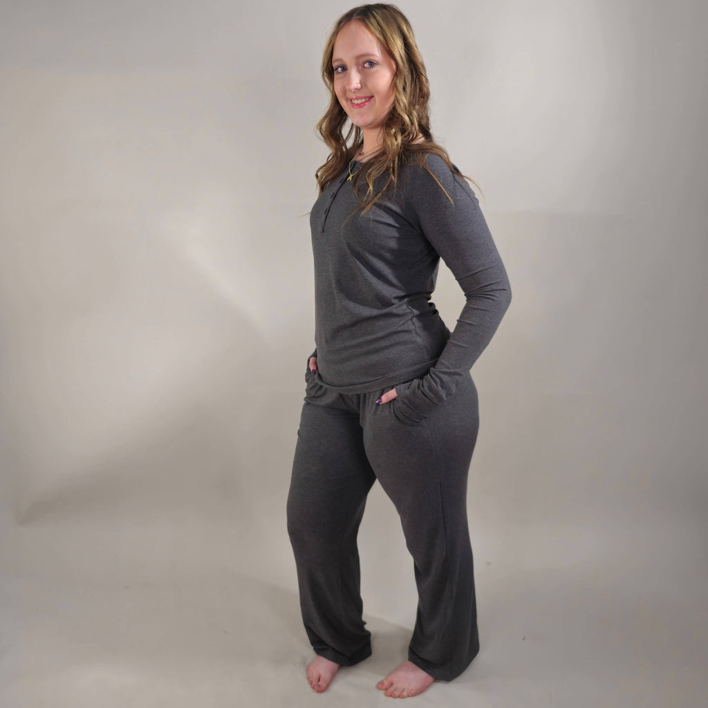 A woman wearing dark grey ribbed wide-leg pants with a relaxed fit. paired with ribbed dark grey long sleeve henley shirt. shown in size large pant and size small shirt. 