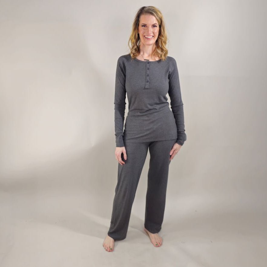 A woman wearing dark grey ribbed wide-leg pants with a relaxed fit. paired with ribbed dark grey long sleeve henley shirt. shown in size XS. 