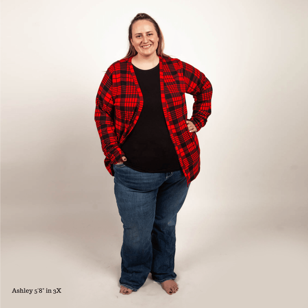 A woman smiling and posing in a red and black plaid cardigan with tailored cuffs and thumbholes. shown in size 3XL