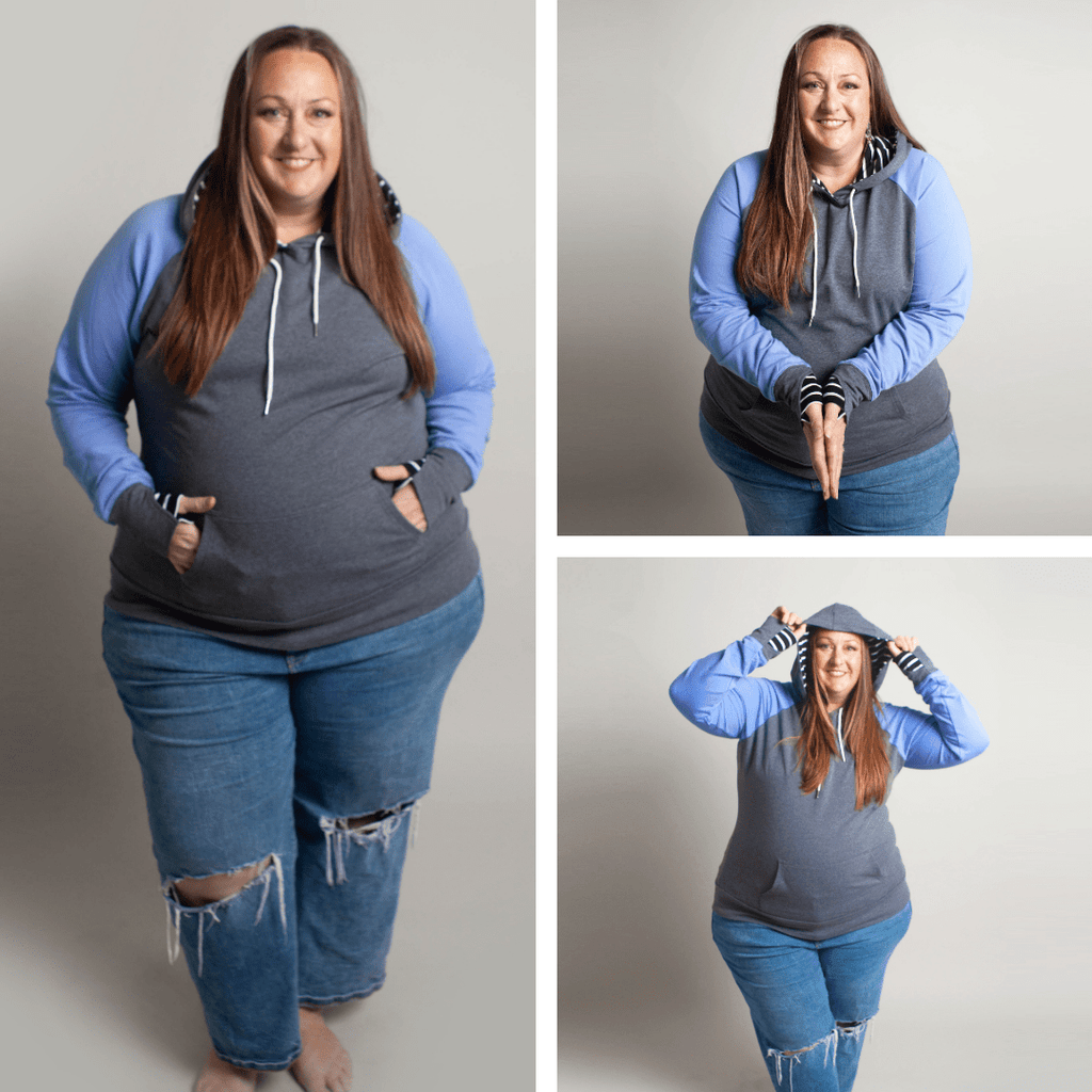 Woman wearing a gray and blue hoodie with kangaroo pocket, grey sleeve cuffs, and a black and white striped pattern on the hood and thumbholes. shown in size 3XL