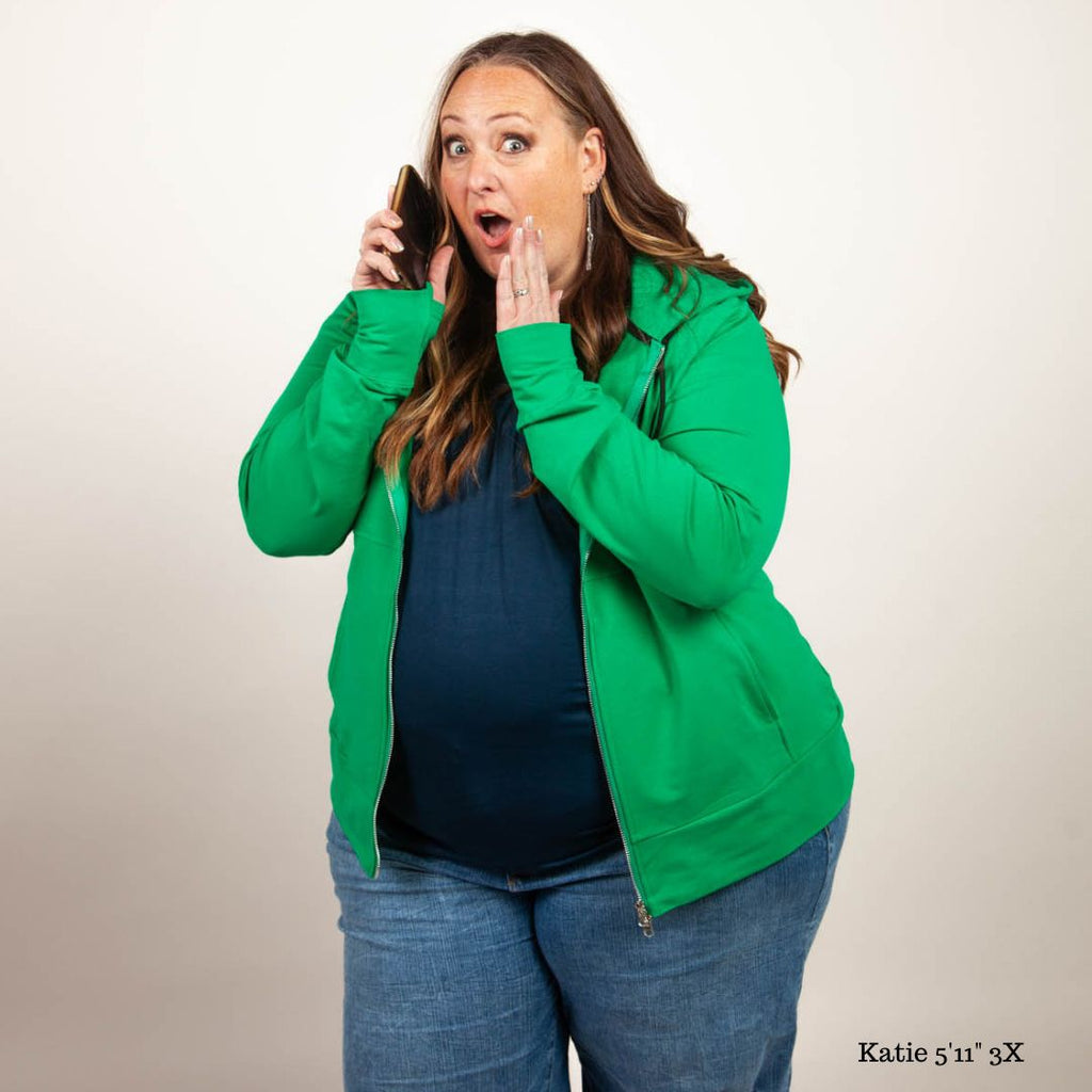 A woman wearing a green full zip hoodie with a hood, thumbholes, and a two-way zipper. shown in size 3XL