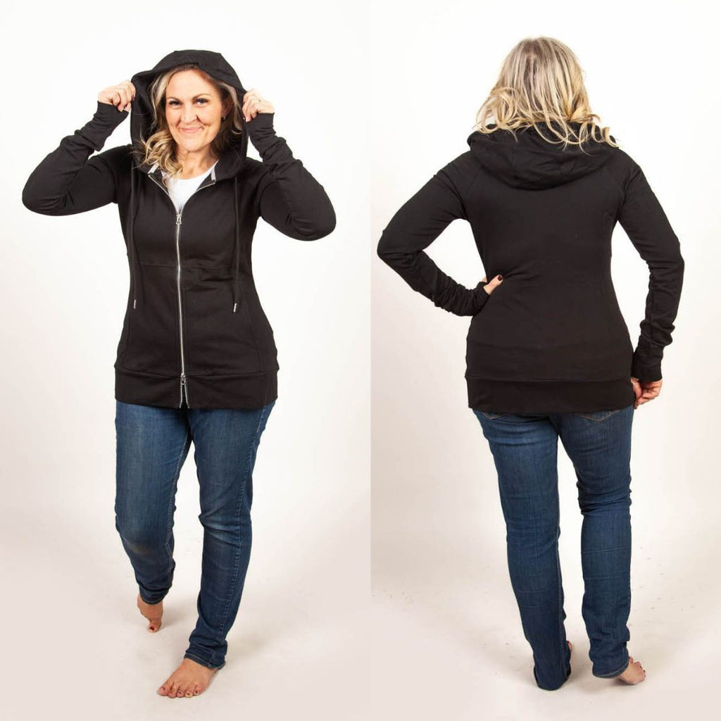 A woman wearing a black full-zip hoodie with a hood, thumbholes, and long sleeves. shown in size medium