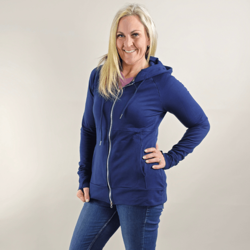 A woman wearing a navy full zip hoodie with a hood, thumbholes, and pockets. shown in size medium