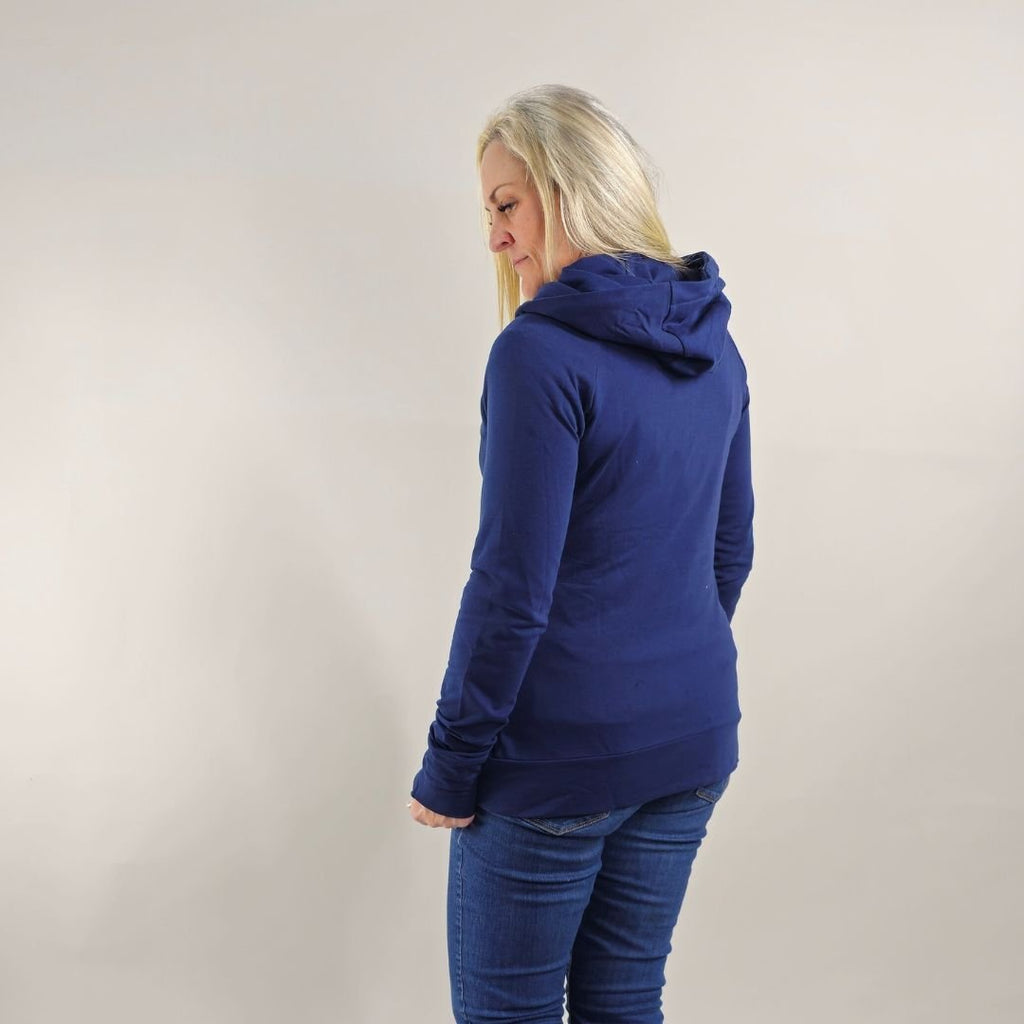A woman wearing a navy full zip hoodie with a hood, thumbholes, and pockets. shown in size medium