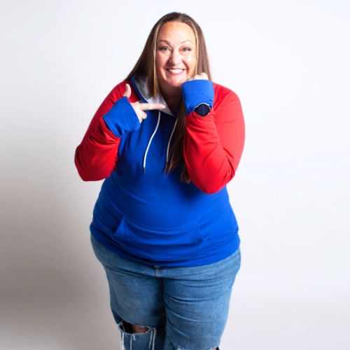Woman wearing a blue and red hoodie with white accents, kangaroo pocket, blue sleeve watch cuffs, and red accent thumbholes. shown in size 3XL