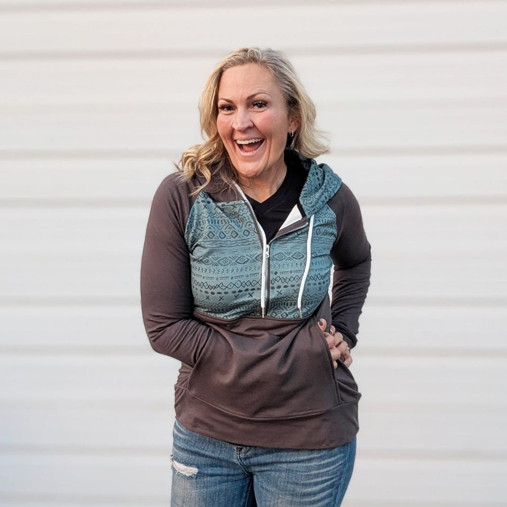 River hoodie half zip with blue azteck top and grey sleeves, bottom half and thumbholes shown in on a women in size M