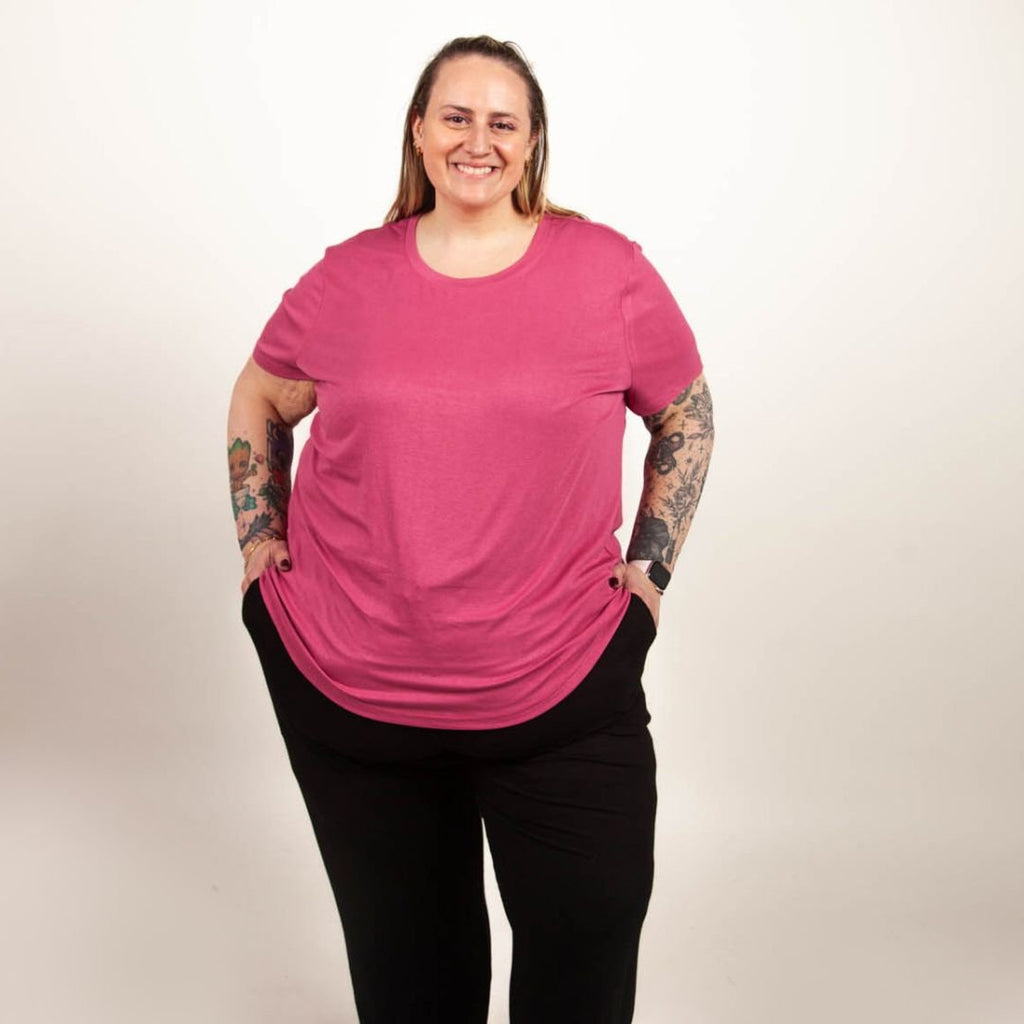 A woman wearing a pink crew neck shirt with short sleeves. shown in size 3XL