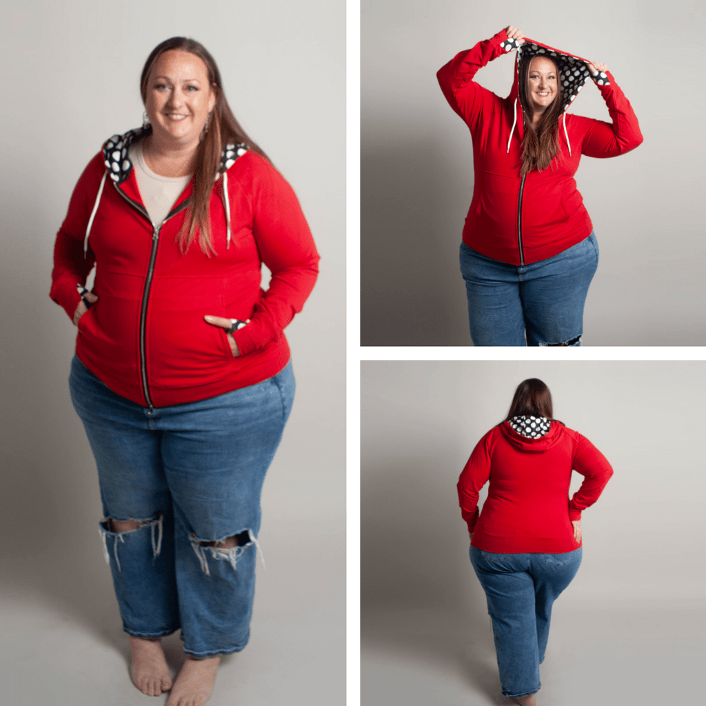 Gallery view of a woman wearing a red zip-up hoodie with a black and white dot lined hood, double zipper, and thumbholes. Shown in size 3XL