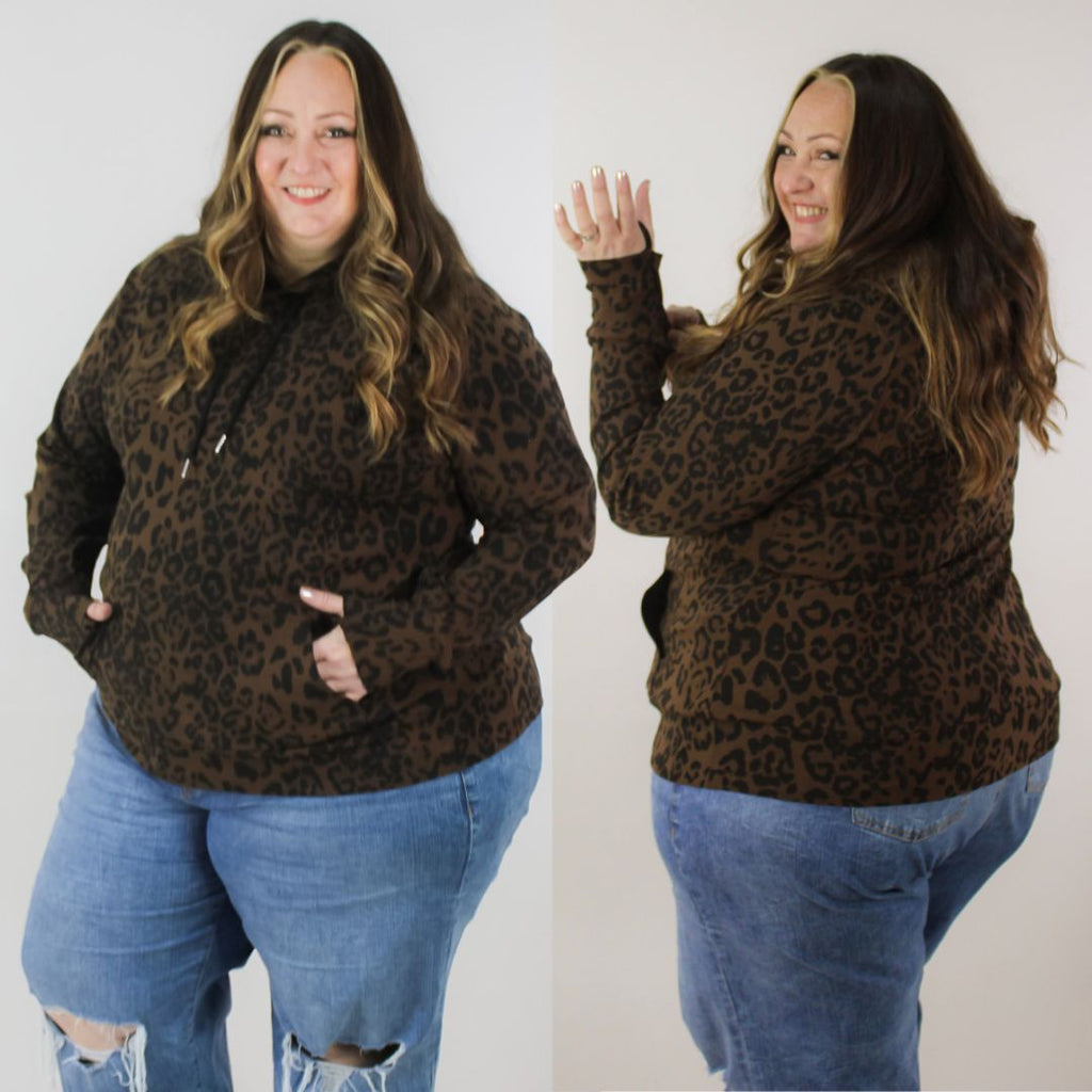 A woman wearing a brown leopard print pullover hoodie with a hood, thumbholes, and a kangaroo pocket. shown in size 3XL