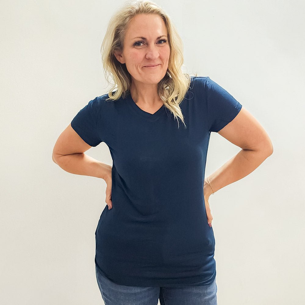 Woman wearing a navy micro ribbed v-neck semi-fitted, longer length shirt. shown in size medium