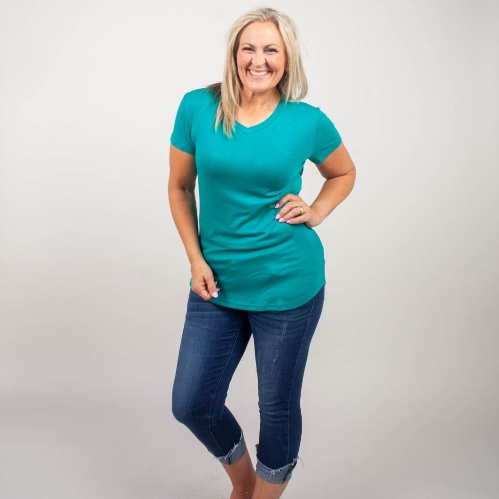 Woman wearing a teal micro ribbed v-neck semi-fitted, longer length shirt. shown in size medium