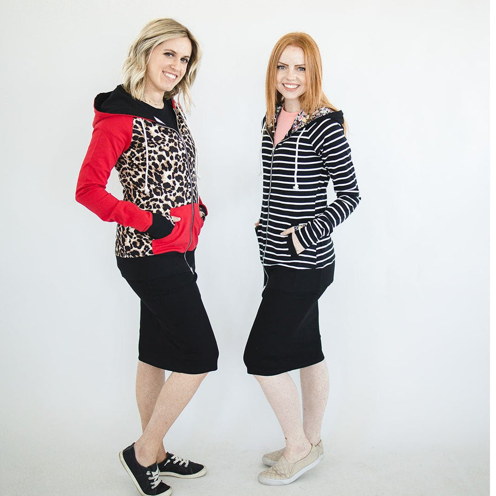 Two women wearing a classic black knit skirt with a knee-length cut, paired with a full zip hoodie and sneakers. 